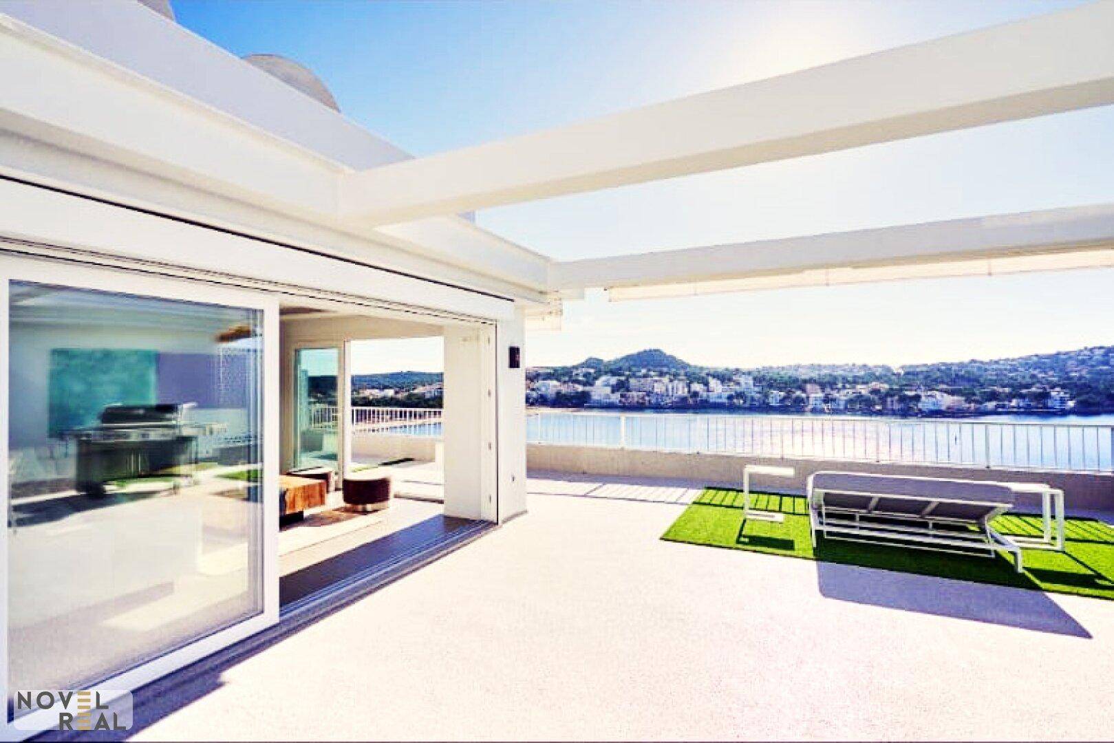 Weitläufige Dachterrasse mit Meerblick und Zugang zu den modernen Innenräumen des Penthouses.
