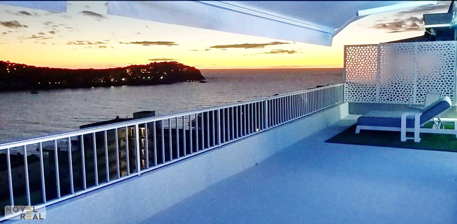 Abendstimmung auf der Dachterrasse mit atemberaubendem Blick auf das Meer bei Sonnenuntergang.