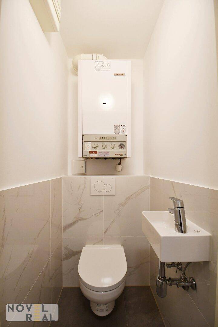 Kleines Gäste-WC mit wandhängender Toilette und kompaktem Waschbecken.