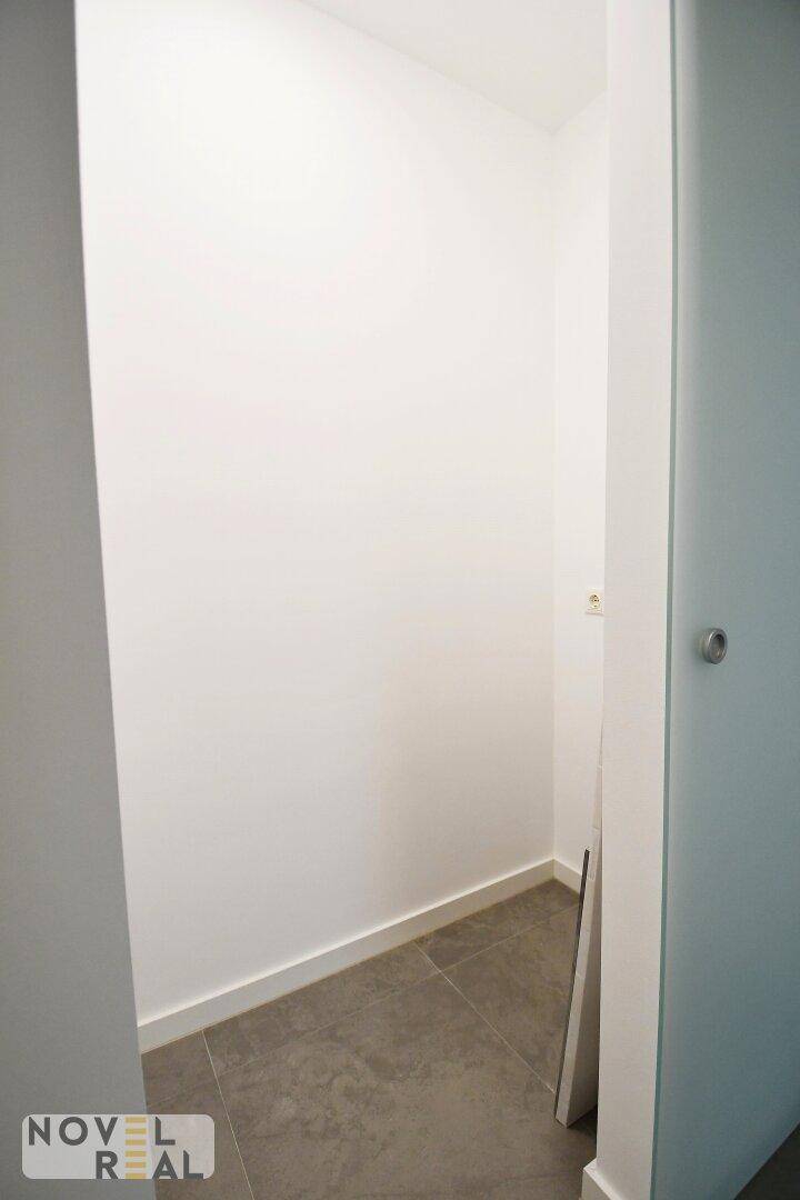 Kleiner Abstellraum mit Fliesenboden und weißen Wänden.