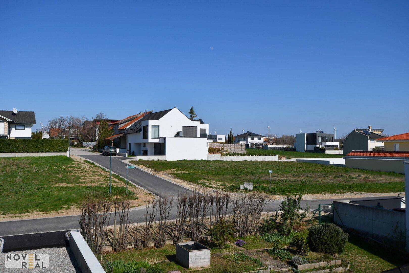 Blick über die Wohnsiedlung mit modernen Häusern und weitläufigen Grünflächen.