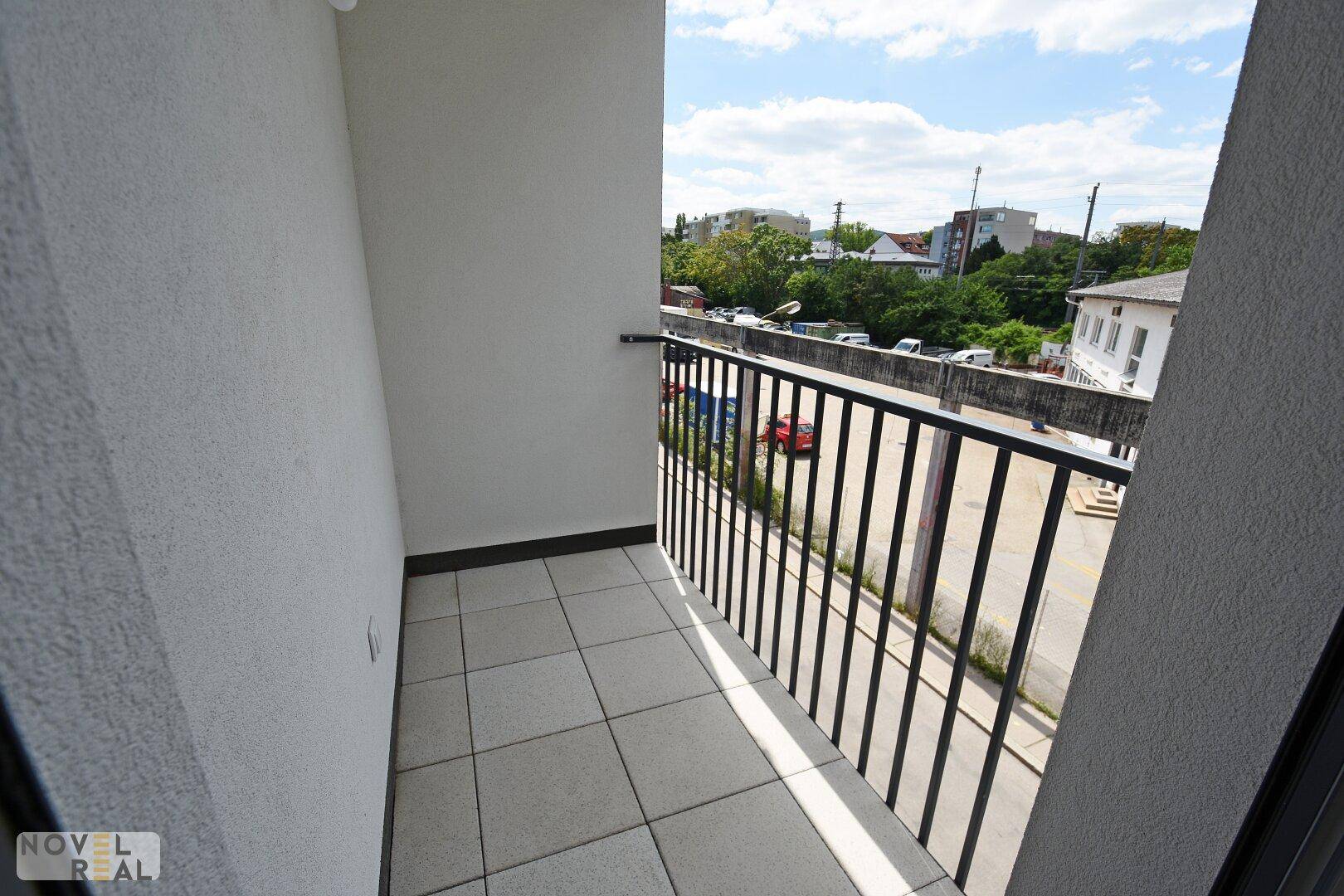 Kleiner Balkon mit Fliesenboden und Metallgeländer, bietet einen Blick auf die Umgebung.