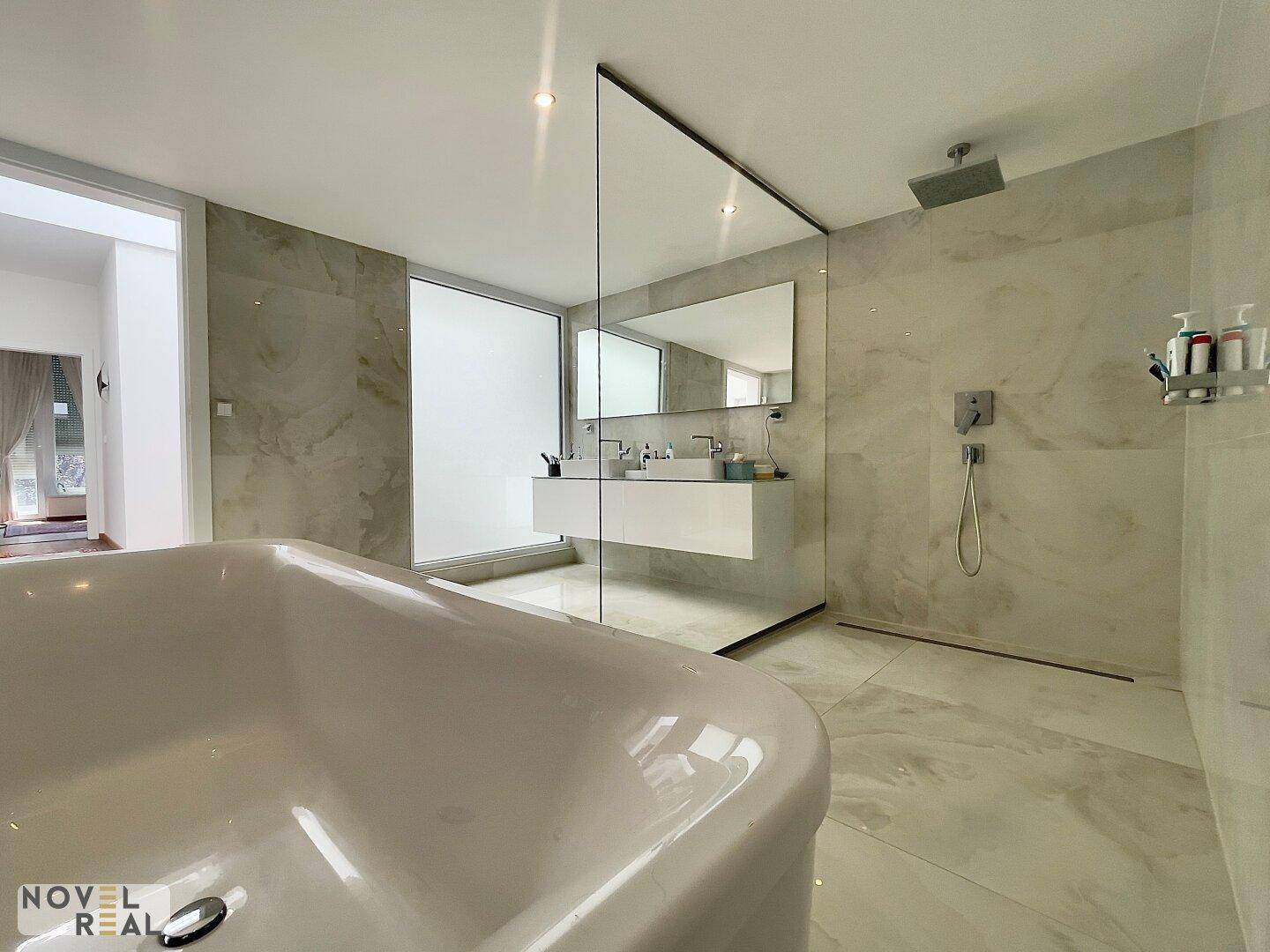 Luxuriöses Badezimmer mit freistehender Badewanne, begehbarer Dusche und Doppelwaschbecken.