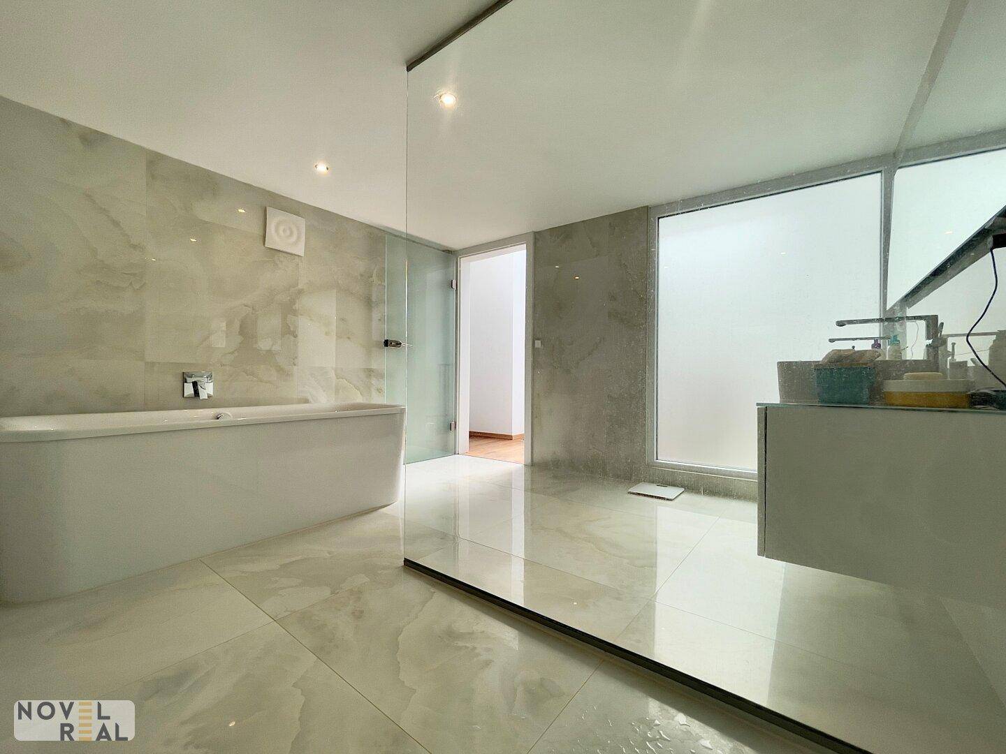 Großzügiges Badezimmer mit freistehender Badewanne, begehbarer Dusche und Doppelwaschbecken.