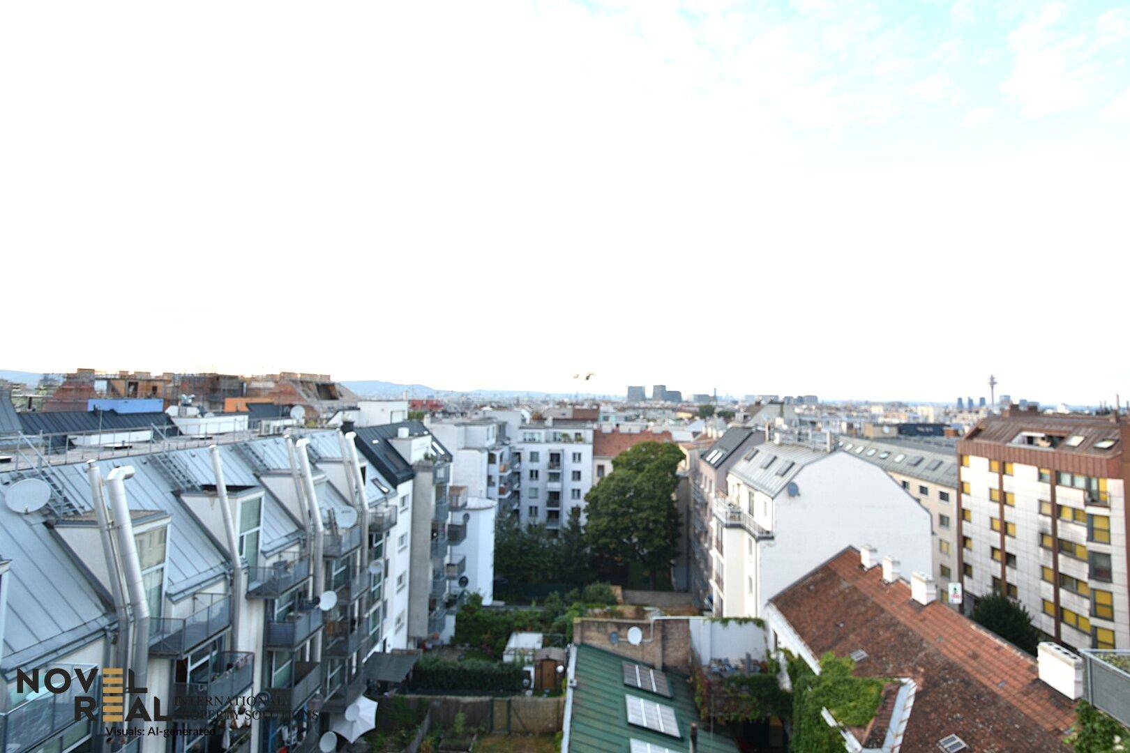 Panoramablick über die Dächer der Stadt mit grünen Innenhöfen und urbaner Bebauung.