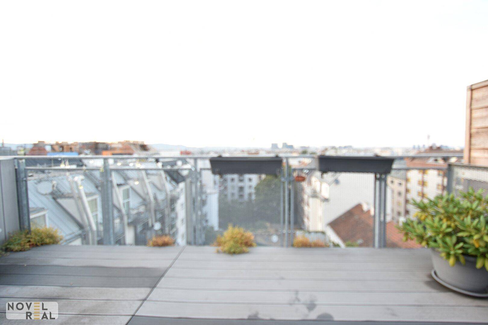 Weitläufige Dachterrasse mit Panoramablick über die Stadt und umliegende Gebäude.