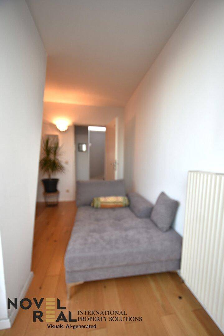 Schmaler Flur mit Holzboden und einer Liege, die als zusätzliche Sitzgelegenheit dient.