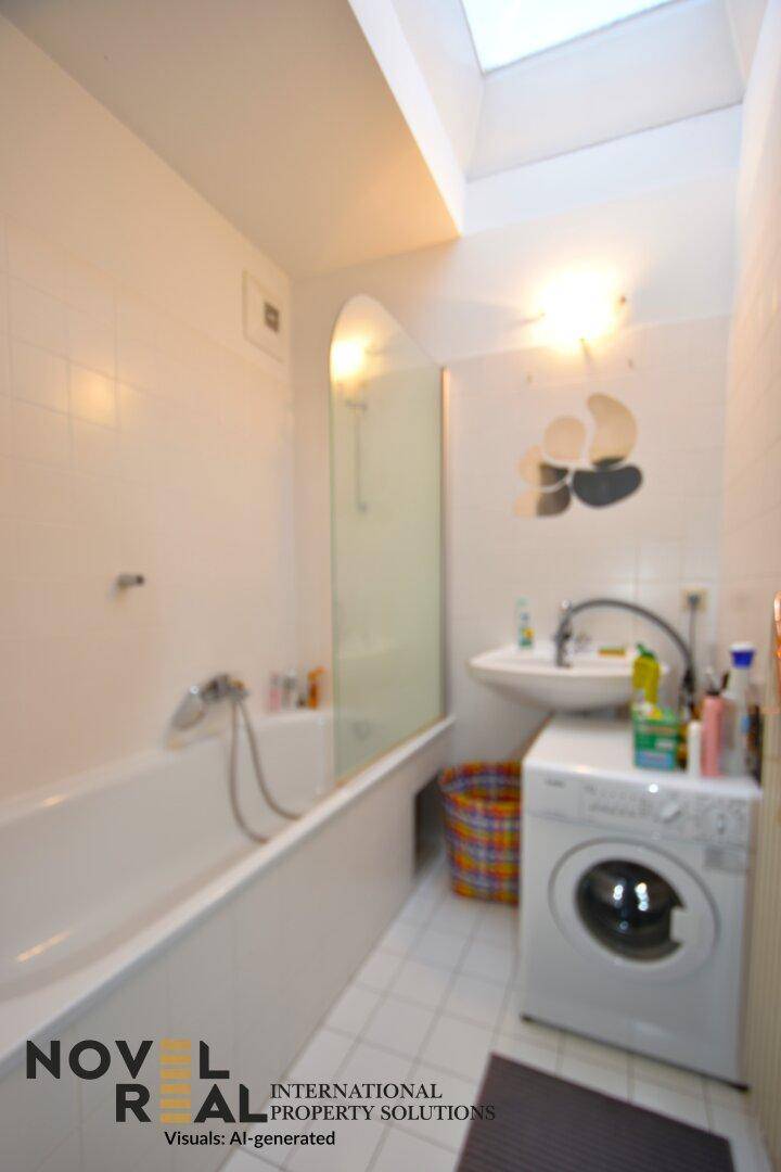 Funktionales Badezimmer mit Badewanne, Waschbecken und integrierter Waschmaschine.