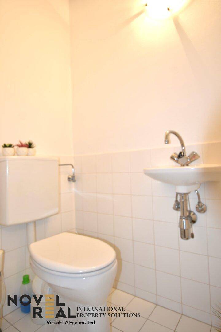 Kleines Gäste-WC mit Toilette, Waschbecken und weißen Fliesen.