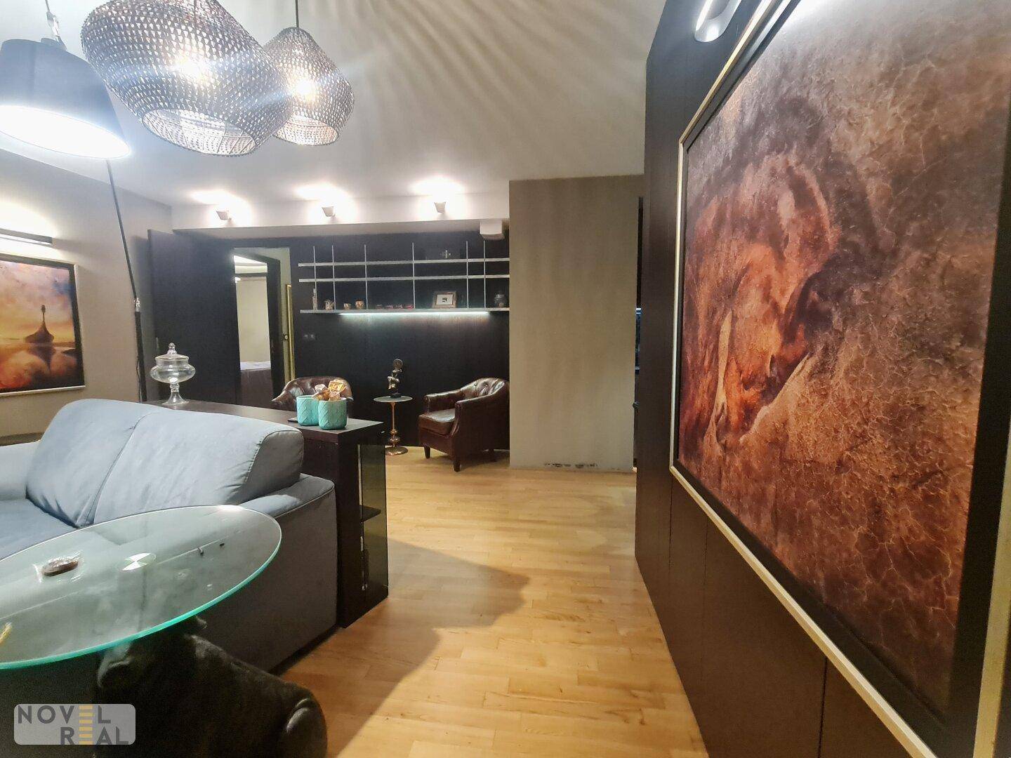 Wohnzimmer mit heller Holzboden, bequemer Couch und integrierten Wandregalen für Dekoration.