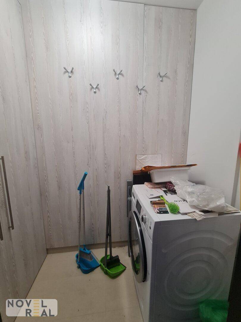 Praktischer Hauswirtschaftsraum mit Waschmaschine, Trockner und integrierten Schränken.