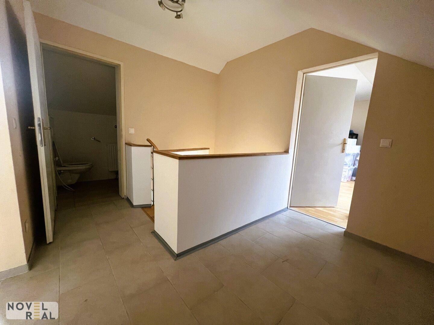 Heller Flur im Dachgeschoss mit Zugang zu weiteren Zimmern und einem Badezimmer.