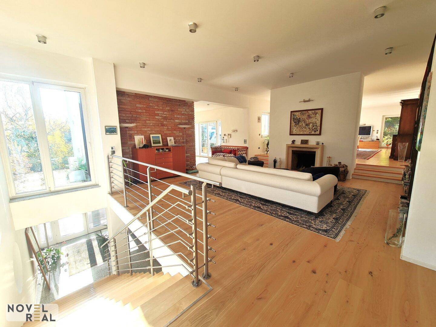 Offener Wohnbereich mit Treppe, Holzboden und Blick auf die untere Etage.