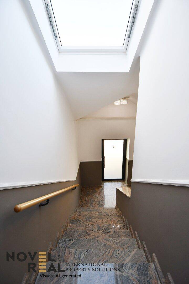 Treppenhaus mit Marmorstufen, Holzgeländer und Oberlicht für natürliches Licht.