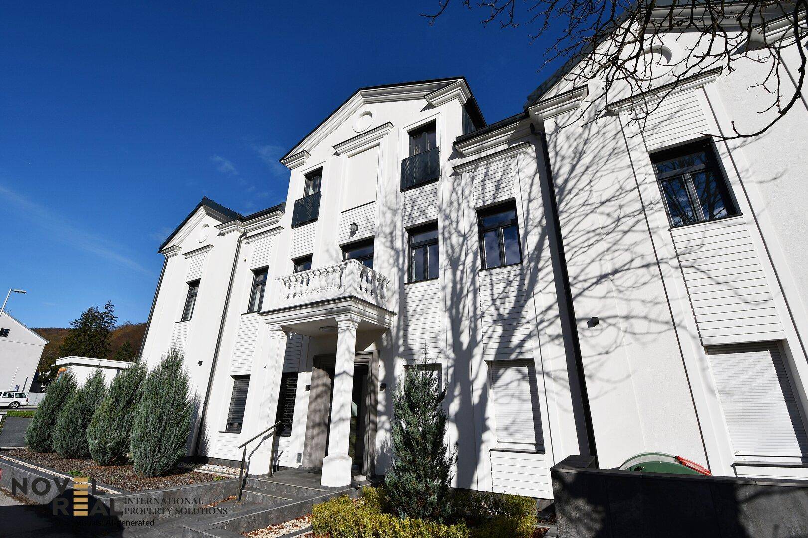 Attraktive weiße Fassade des Gebäudes mit modernen Fenstern und Balkonen.