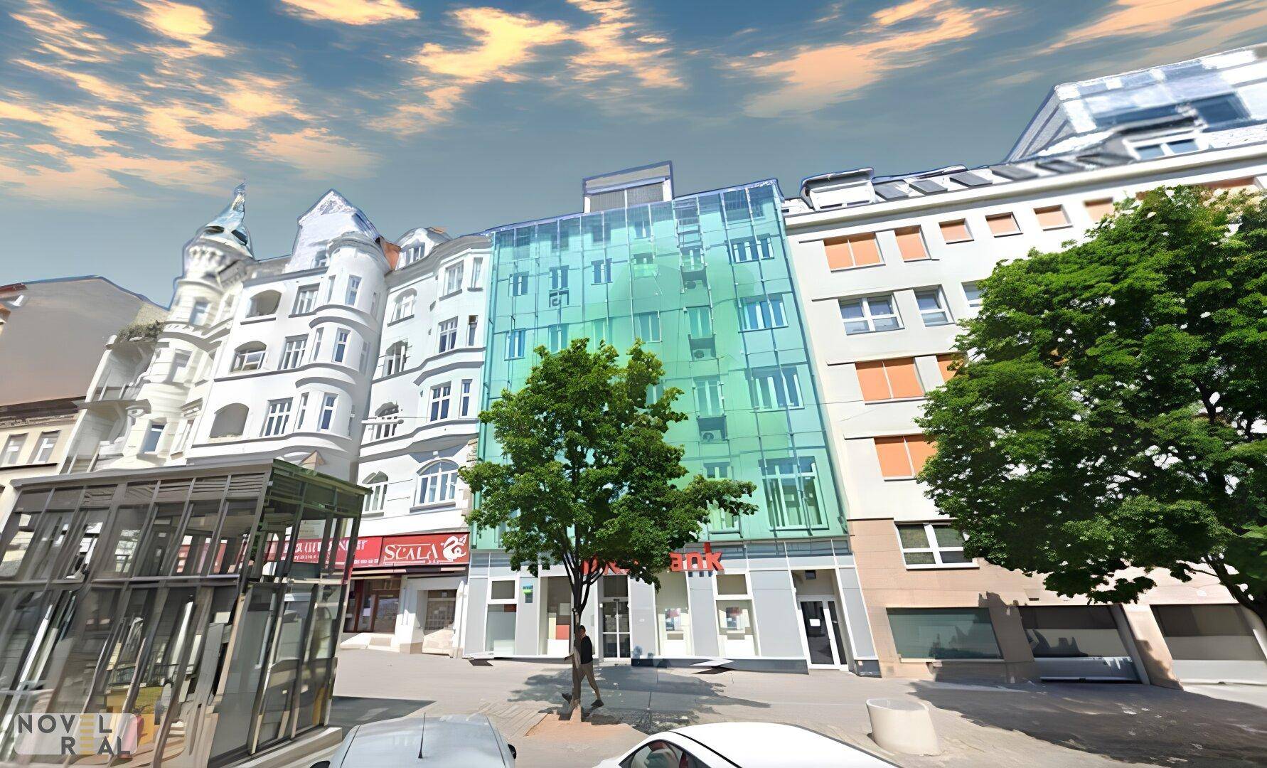 Moderne Gebäudefassade mit grünen Glasflächen und traditionellen Nachbargebäuden in der Stadt.