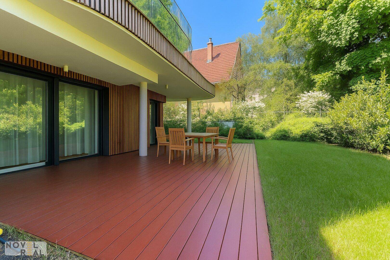 Geräumige Holzterrasse mit Gartenmöbeln und Blick ins Grüne, angrenzend an ein modernes Gebäude.