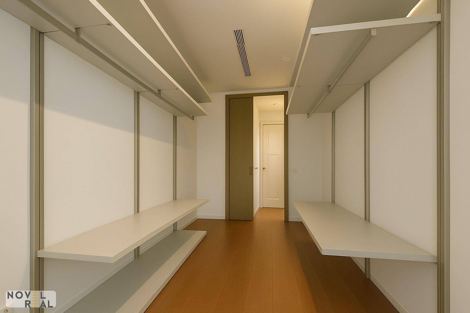 Geräumiger begehbarer Kleiderschrank mit offenen Regalsystemen und Holzfußboden.