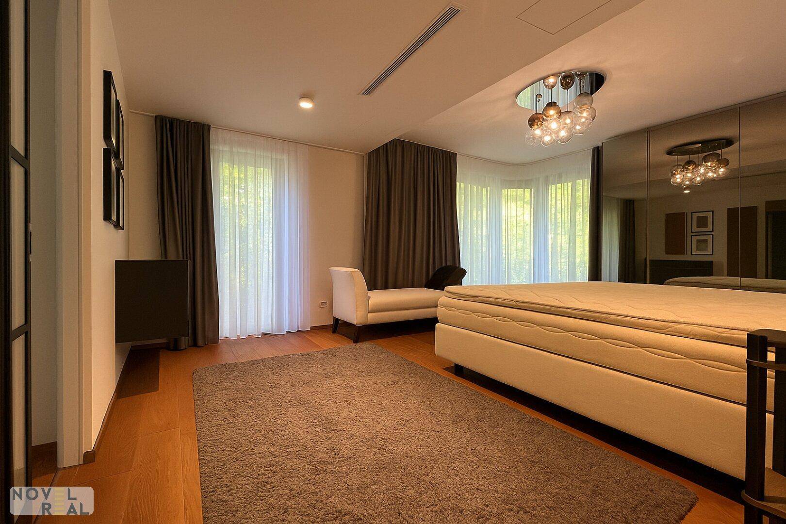 Gemütliches Schlafzimmer mit großem Bett, Teppich und Spiegelschränken, hell und modern eingerichtet.