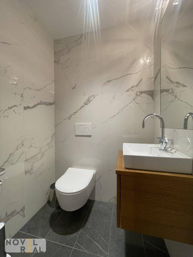 Kleines, modernes Gäste-WC mit Waschtisch und wandhängendem WC, elegant gefliest.