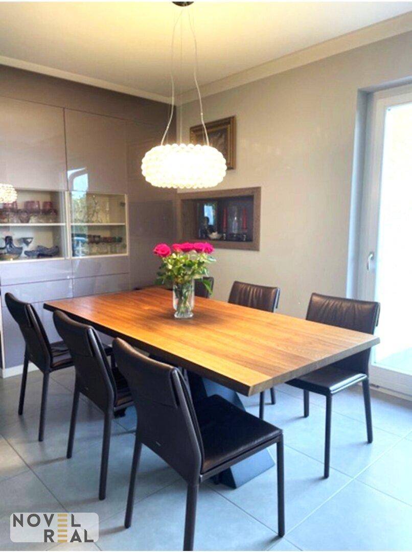 Eleganter Essbereich mit großem Holztisch, modernen Stühlen und stilvoller Pendelleuchte.