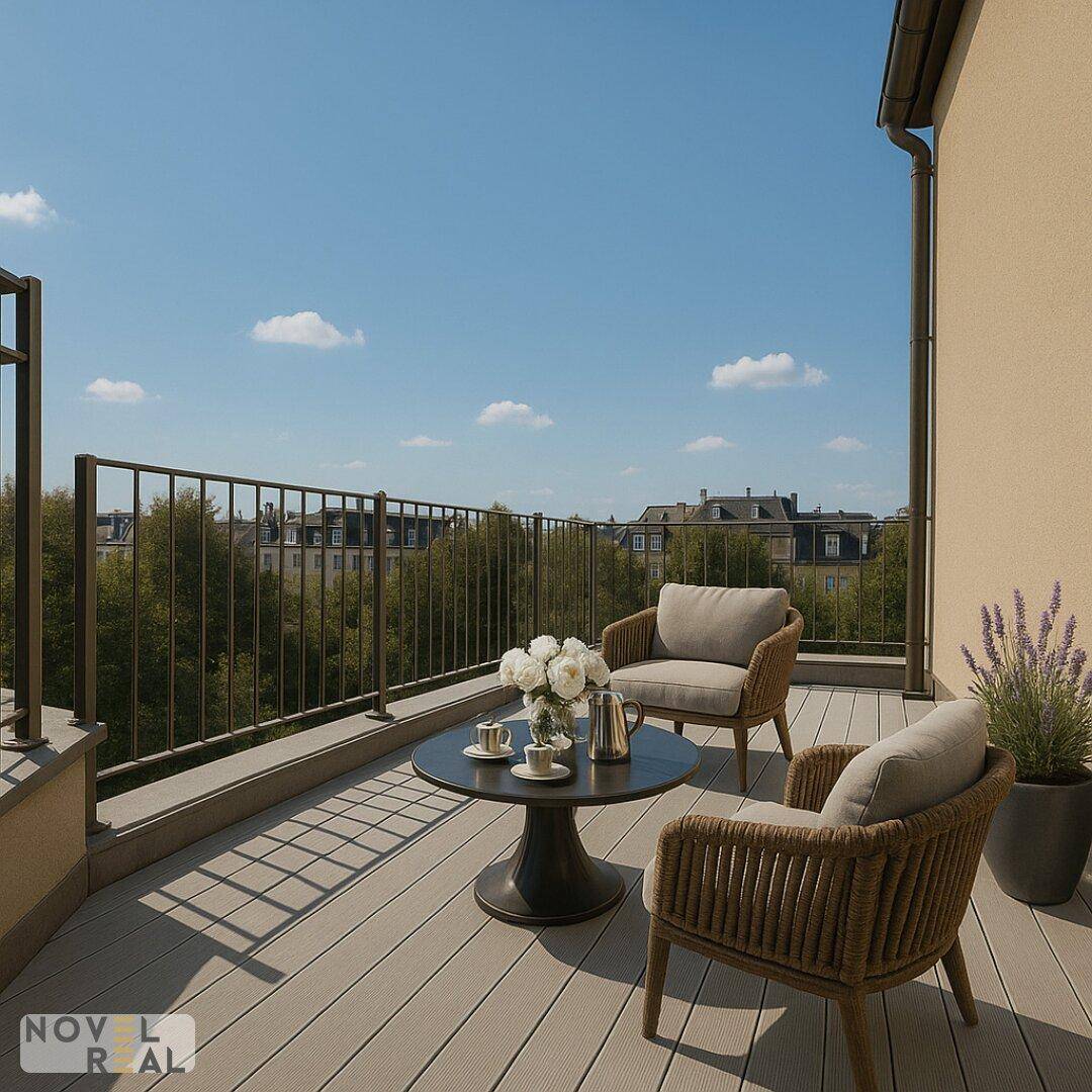 Heller Balkon mit bequemen Sitzmöbeln, einem Tisch und Blick auf die grüne Umgebung.