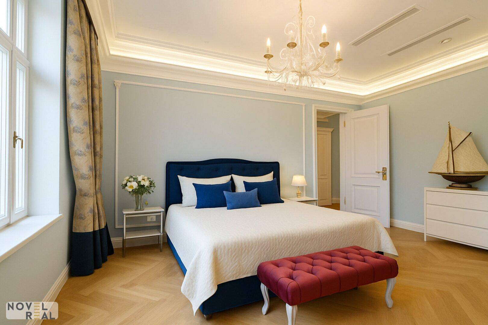 Stilvolles Schlafzimmer mit Fischgrätparkett, blauer Bettumrandung und Kronleuchter.
