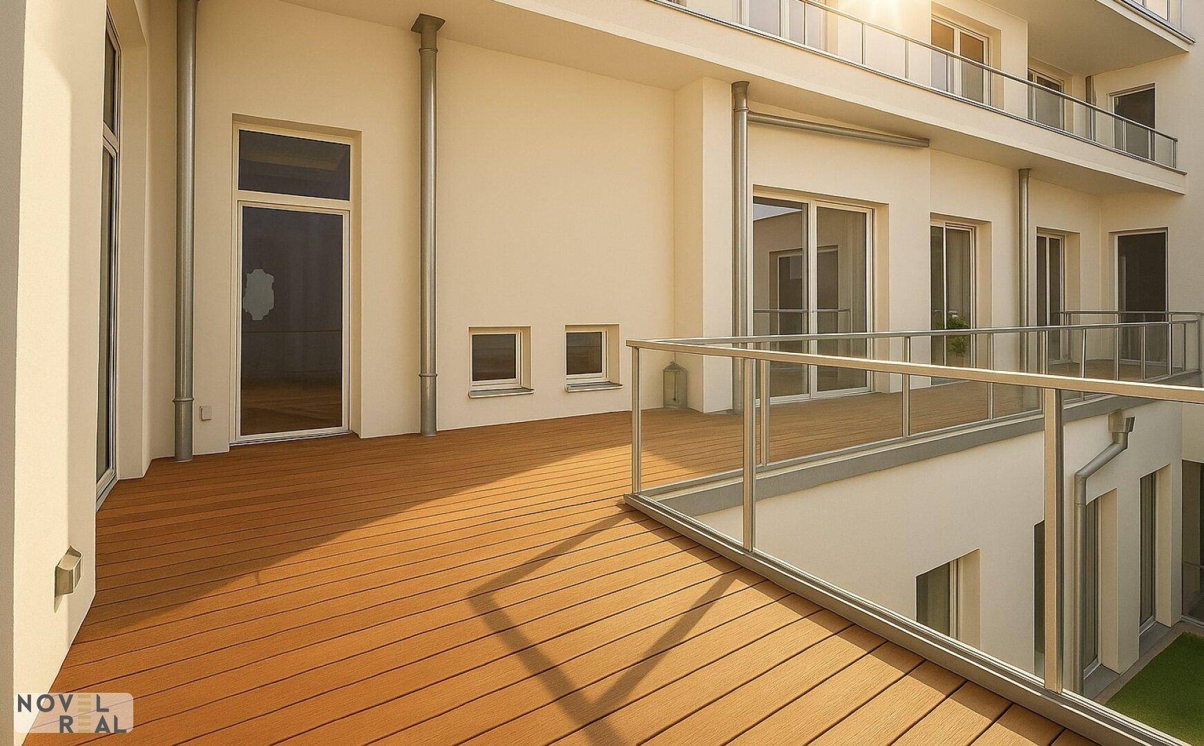 Geräumige Holzterrasse mit Glasgeländer und viel Sonnenlicht.