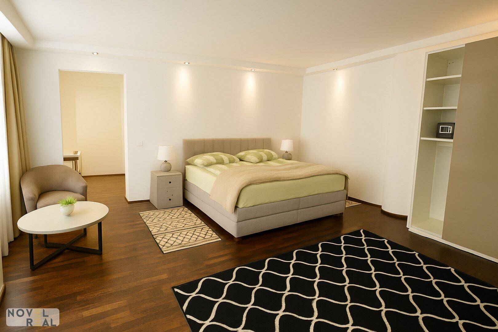 Schlafzimmer mit großem Bett, Sessel und offenem Kleiderschrank mit Regalen.