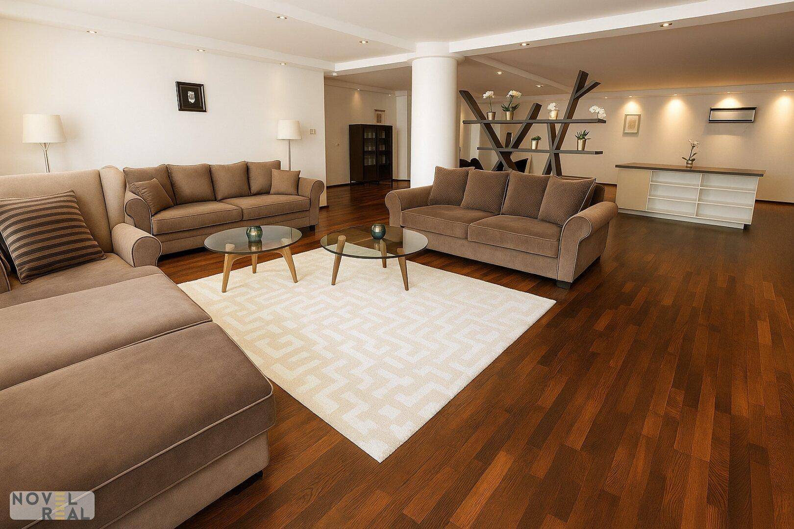 Gemütliches Wohnzimmer mit bequemen Sofas, Holzboden und dekorativem Raumteiler.