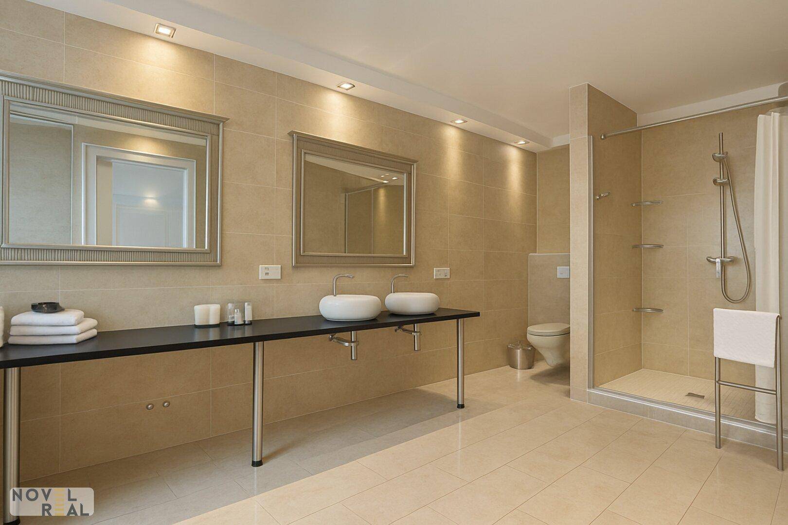 Geräumiges Badezimmer mit begehbarer Dusche, Doppelwaschbecken und beigefarbenen Fliesen.