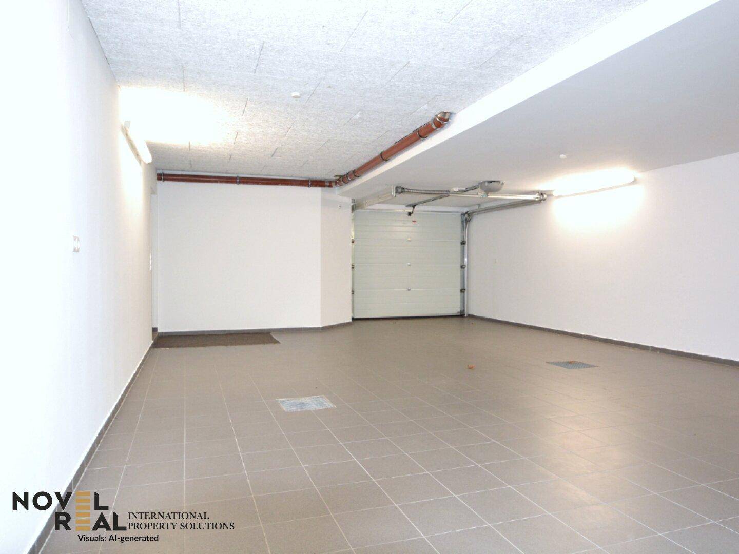 Geräumige Garage mit Fliesenboden und automatischem Garagentor.