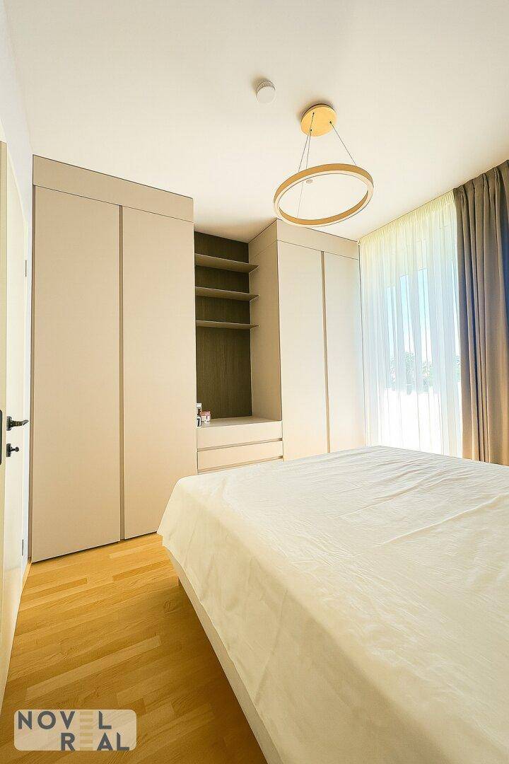 Schlafzimmer mit Doppelbett, Einbauschränken und hellem Holzboden.