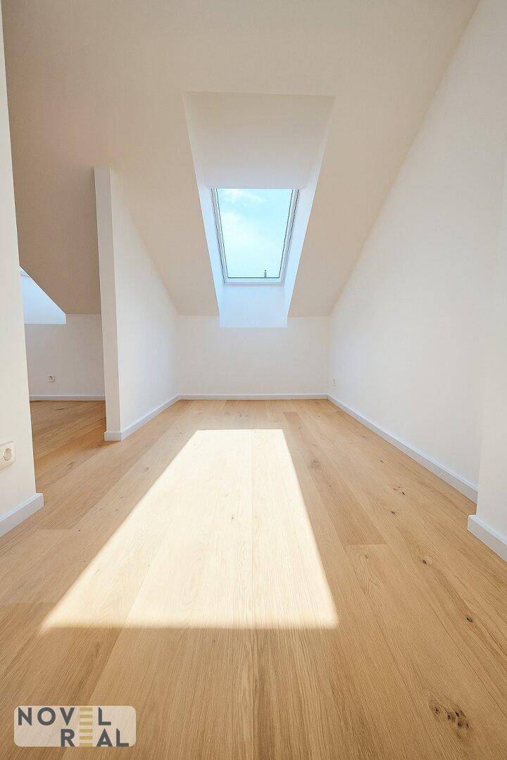 Lichtdurchfluteter Raum mit Holzboden und einem großen Dachfenster, das den Raum erhellt.