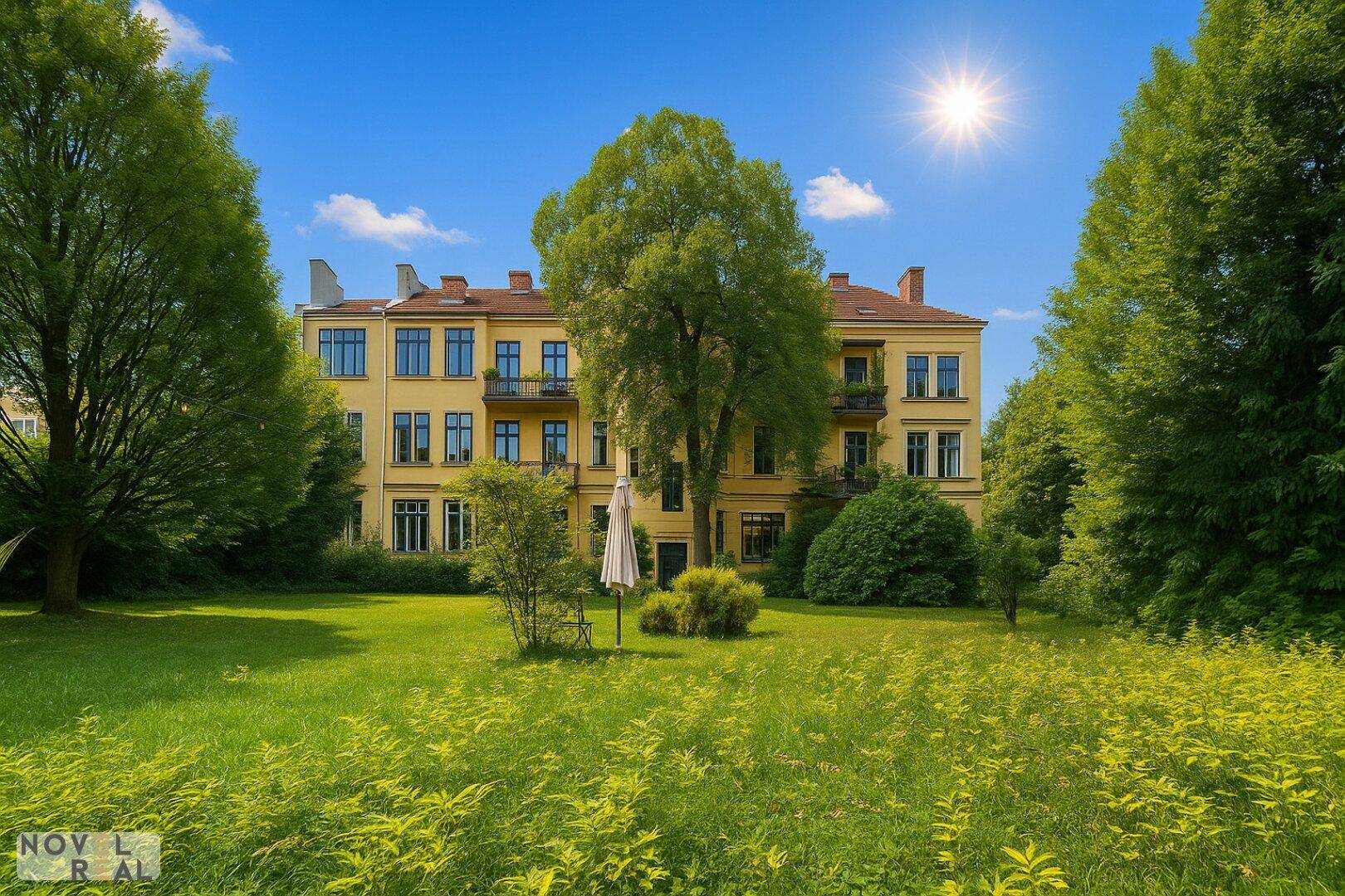 Großzügiger Gartenbereich vor einem eleganten Mehrfamilienhaus mit klassischer Architektur und viel Grün.