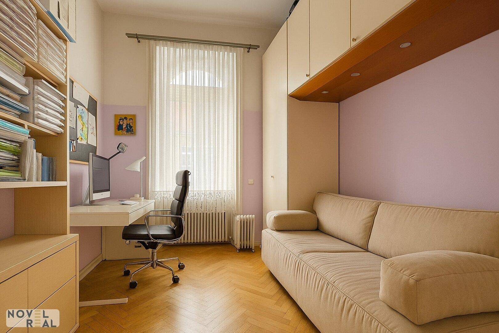Helles Arbeitszimmer mit Schreibtisch, Sofa und integrierten Schränken für Stauraum.