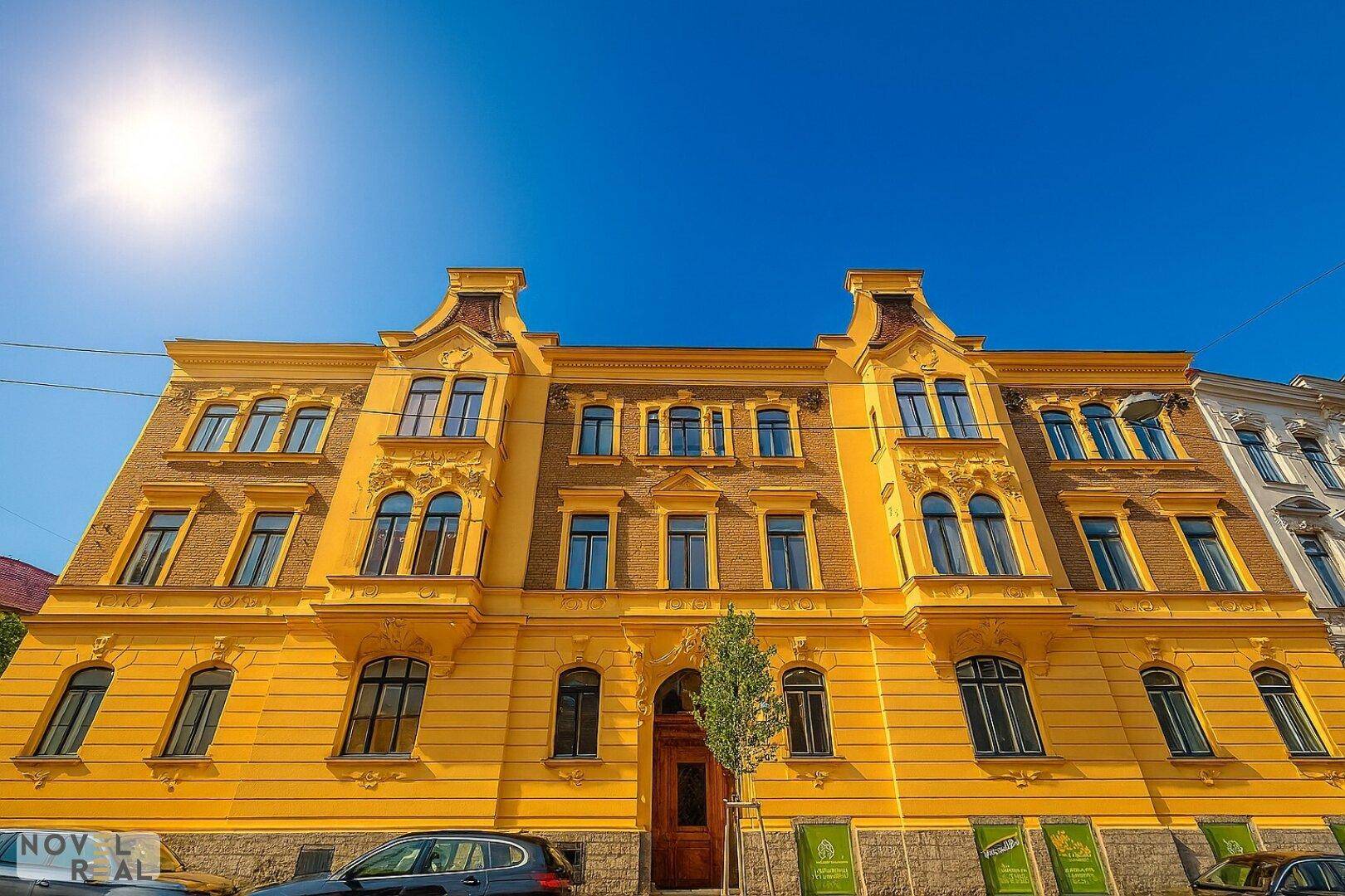 Historisches Gebäude mit gelber Fassade und detailreichen architektonischen Elementen.
