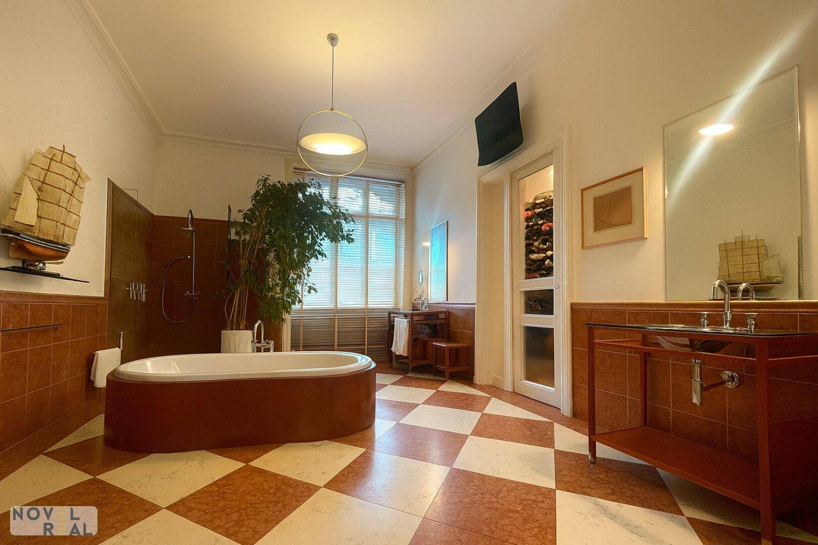 Elegantes Badezimmer mit Doppelwaschbecken, Badewanne und Zugang zu einem Weinregal.
