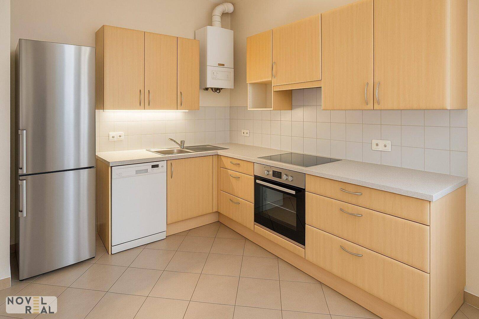 Funktionale Küche mit hellen Holzfronten, Edelstahlkühlschrank und integrierten Geräten.