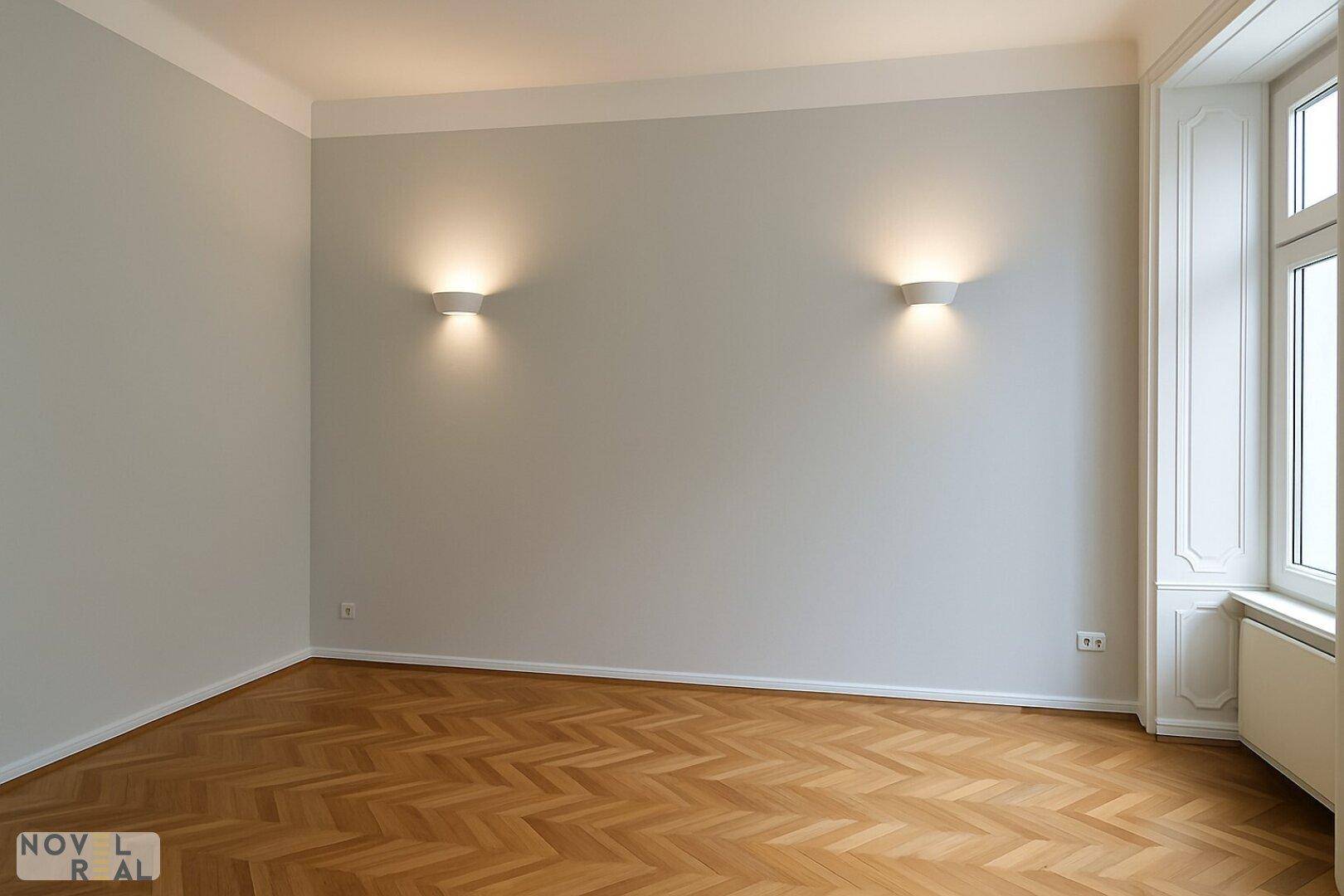 Gemütliches Zimmer mit Fischgrätparkett und Wandleuchten, ideal für ein Schlafzimmer.