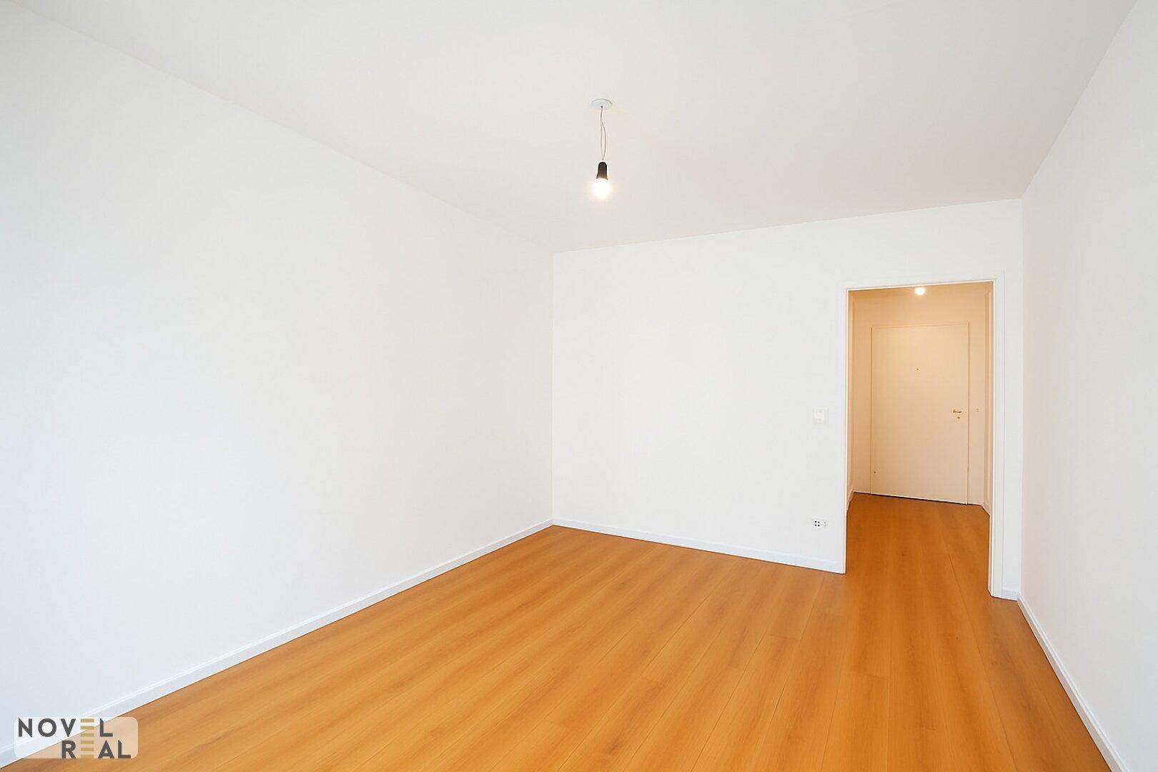 Leerer Raum mit Holzboden und weiß gestrichenen Wänden, bereit zur Einrichtung als Schlaf- oder Arbeitszimmer.