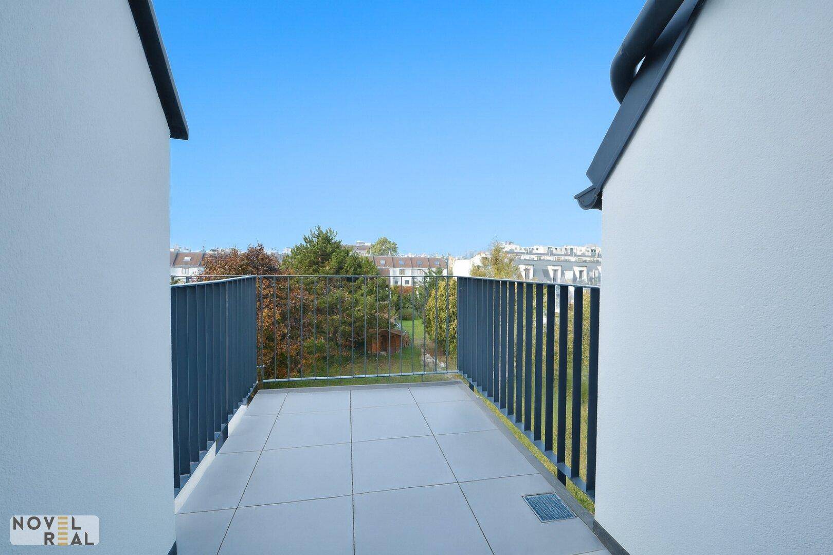 Geräumiger Balkon mit Fliesenboden und Blick ins Grüne, bereit zur individuellen Gestaltung.