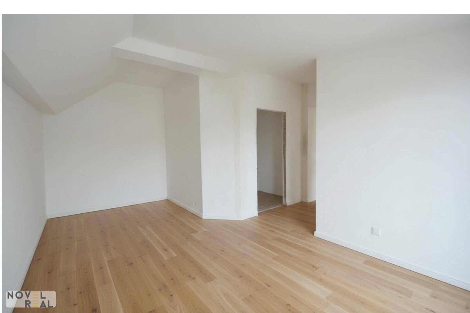 Geräumiges, helles Zimmer mit Holzboden und leichter Dachschräge, vielseitig nutzbar.