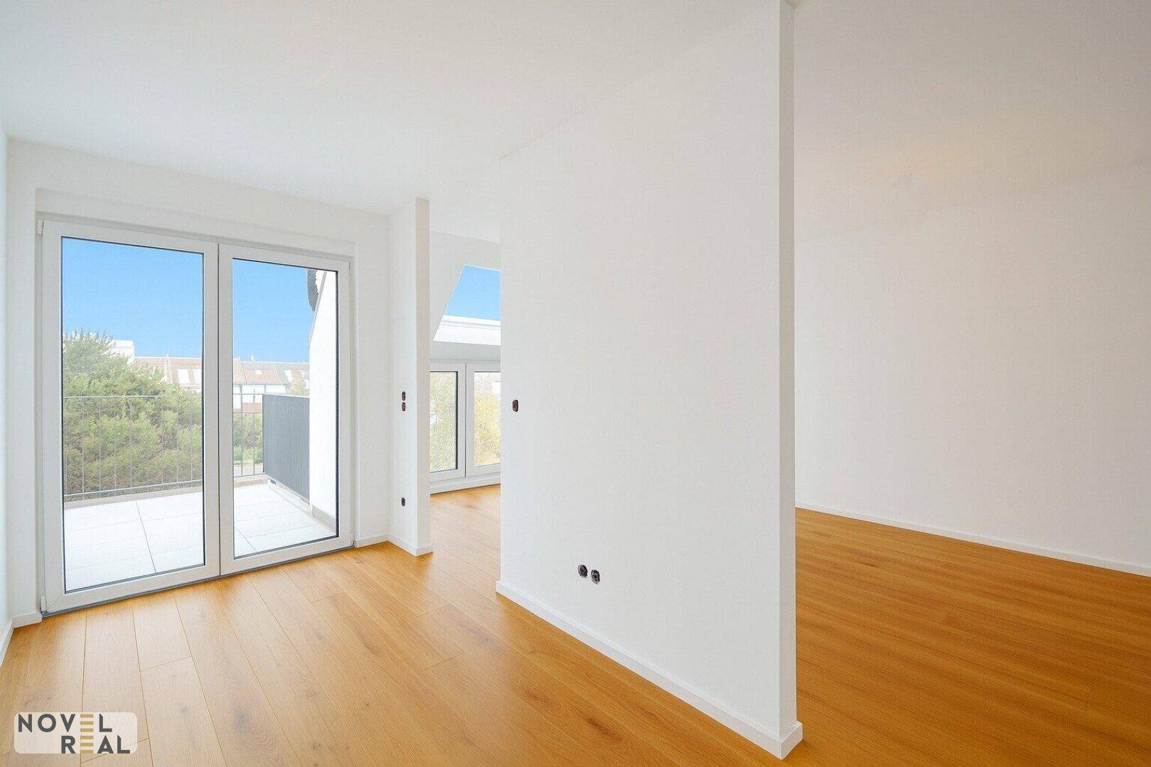 Heller Raum mit Holzboden und Zugang zu einem großen Balkon, ideal für flexible Nutzung.