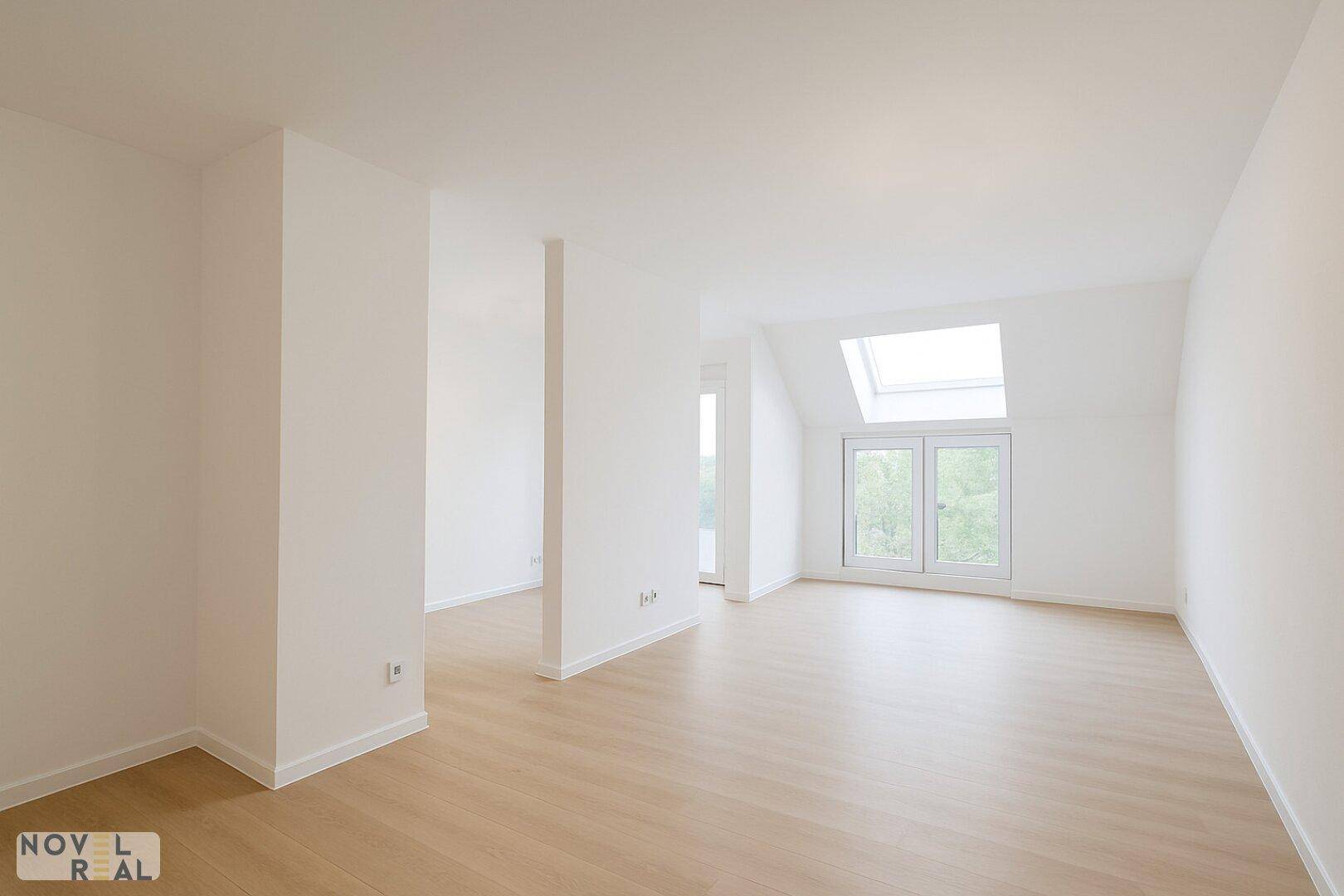 Großzügiger, heller Raum mit Holzboden und Dachschräge, ideal für individuelle Einrichtung.