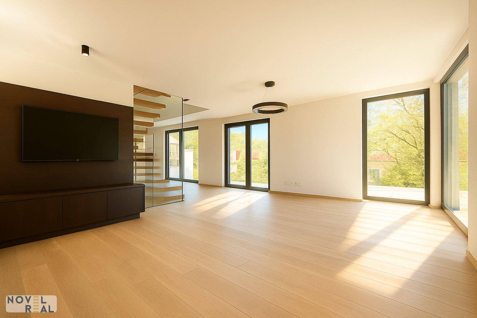 Helles, modernes Wohnzimmer mit Holzboden, großen Fenstern und Blick ins Grüne.