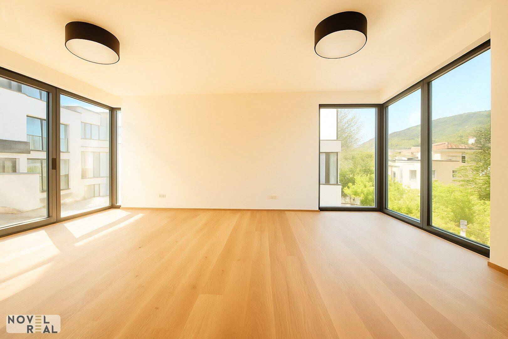 Heller Raum mit großen Fenstern, Holzboden und viel Tageslicht, ideal für Wohnen oder Schlafen.