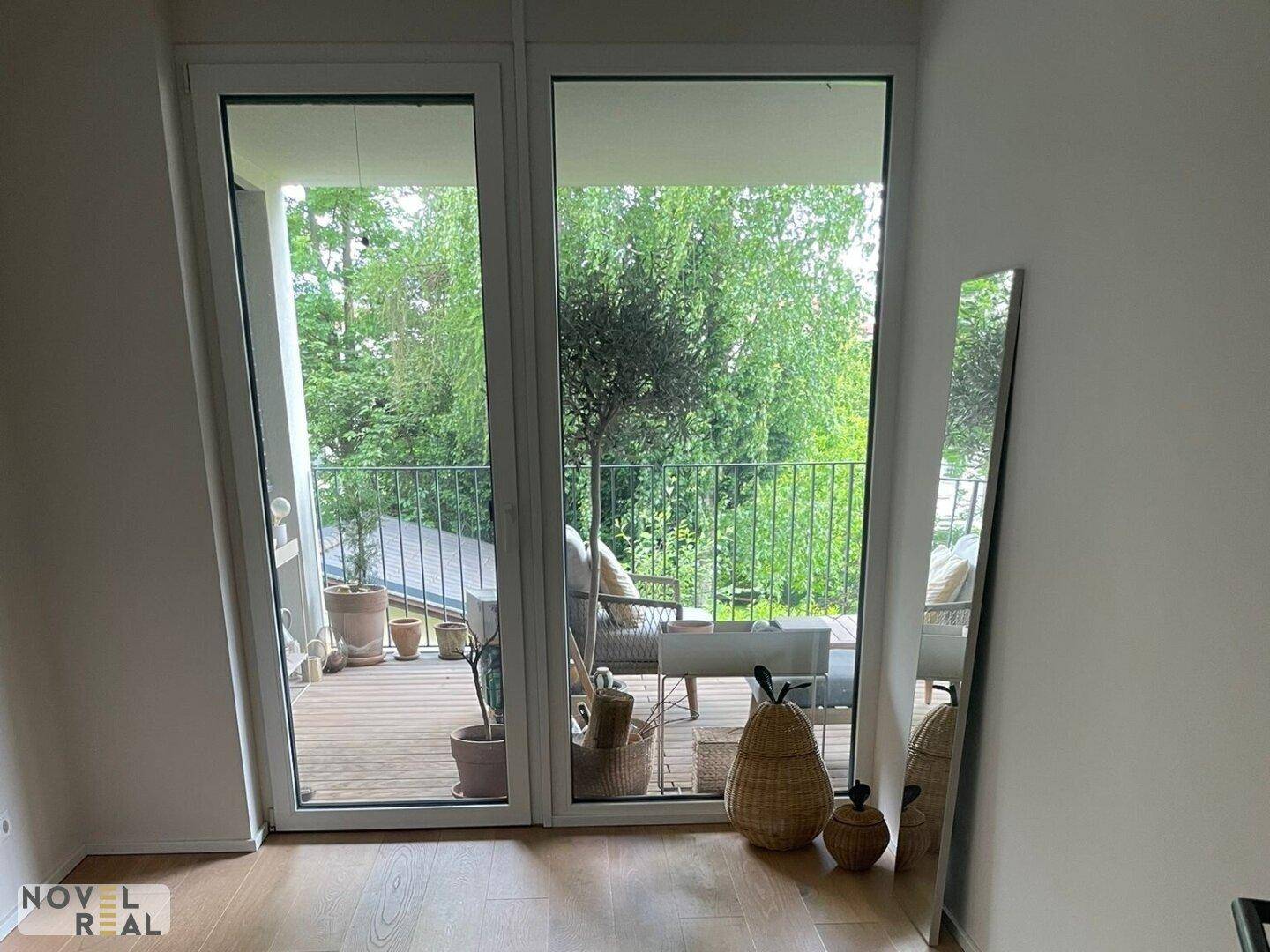 Schlafzimmer mit großen Fenstern, die viel Licht hereinlassen und Zugang zum Balkon bieten.