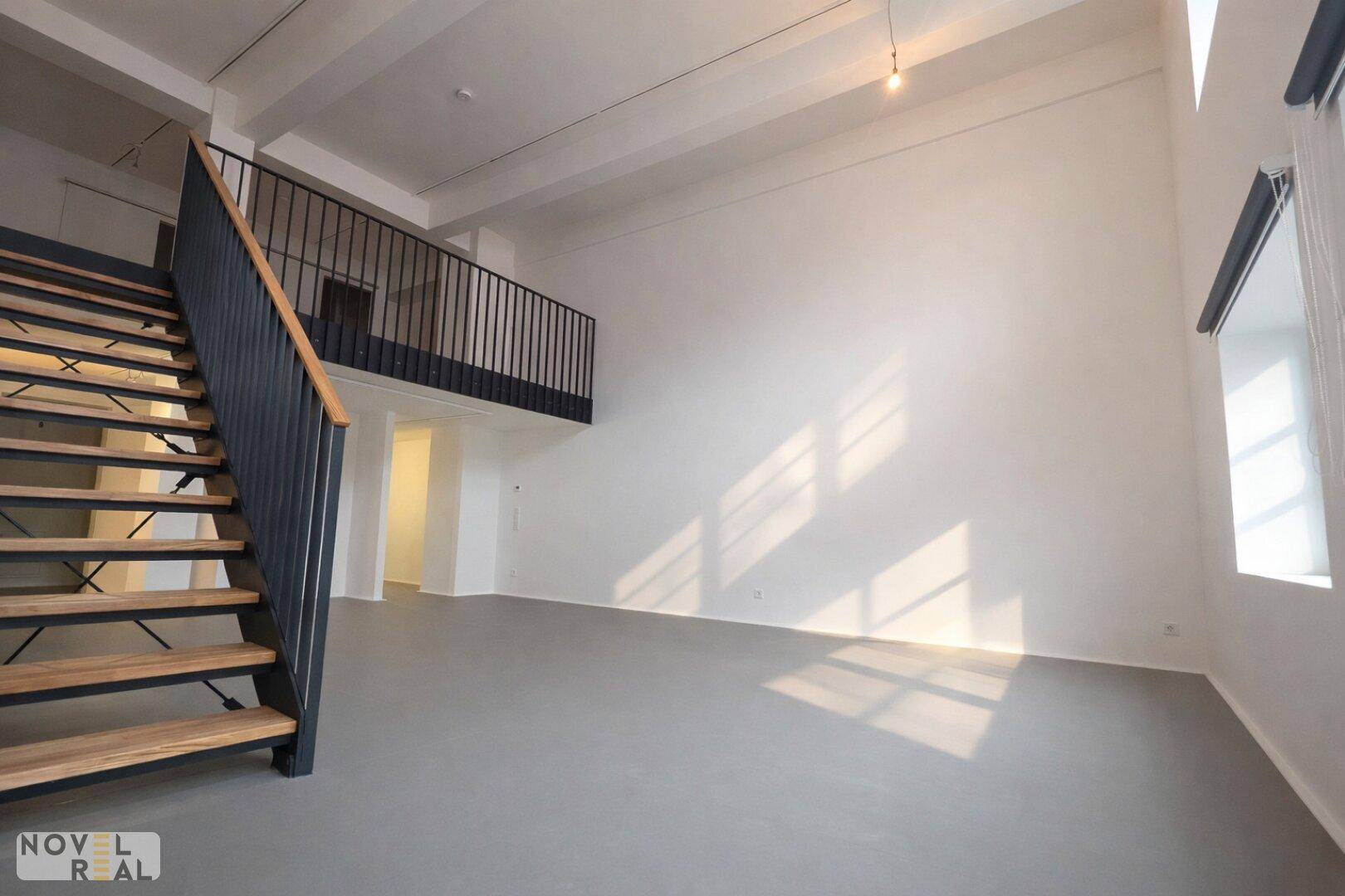 Geräumiger Wohnbereich mit hohen Decken, viel Tageslicht und Zugang zur oberen Galerie.