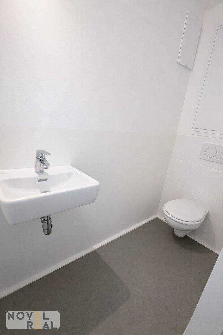 Kleines Gäste-WC mit modernem Waschbecken und wandhängender Toilette.